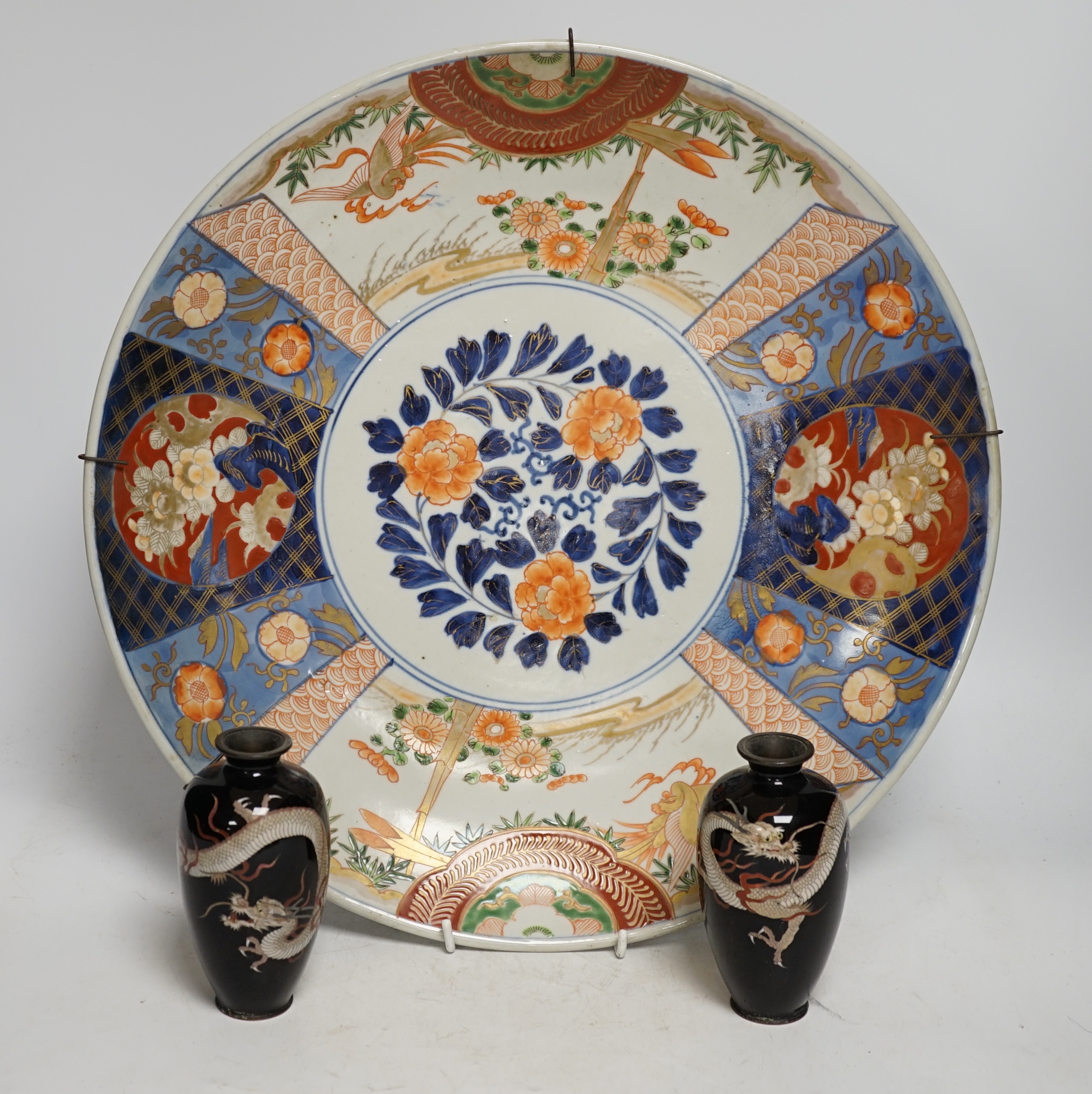 A pair of Japanese cloisonné enamel ‘dragon’ vases and a Japanese Imari dish, 39.5cm diameter (3). Condition - fair to good